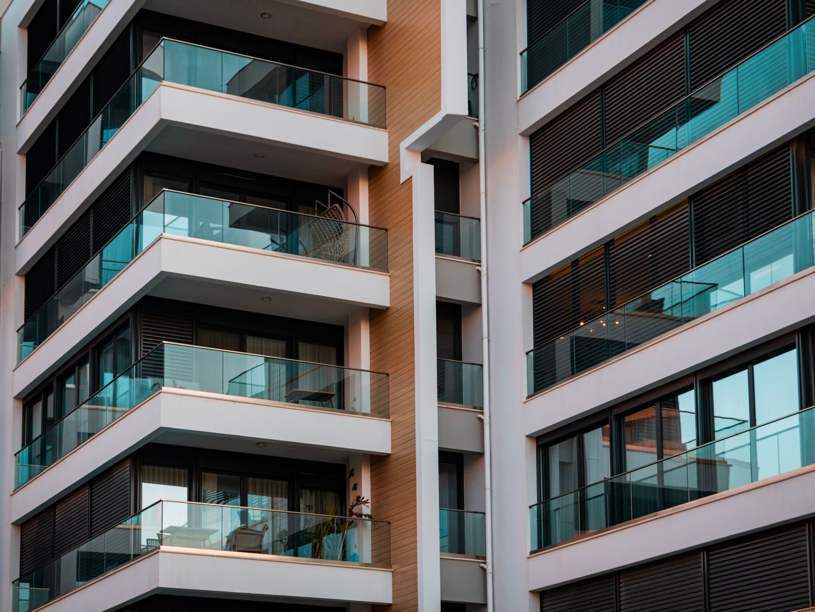 Facade detail: glass-railed balconies, teak cladding and shutters